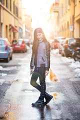 Fototapeta premium Brunette woman portrait posing in the street. Back light effect,