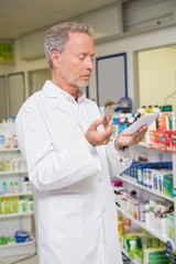 Pharmacist reading prescription and holding medicine