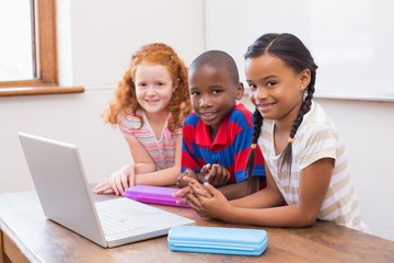Fototapeta na wymiar Cute pupils using computer