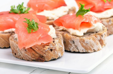 Sandwiches with salmon on white plate