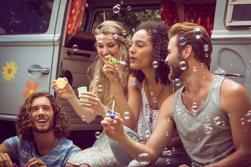 Hipsters blowing bubbles in camper van