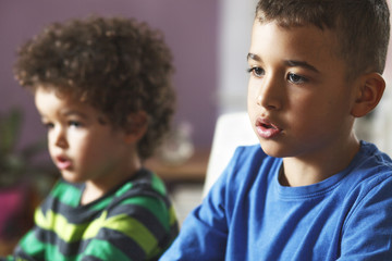 Obraz premium Two brothers sitting and watching cartoons on television