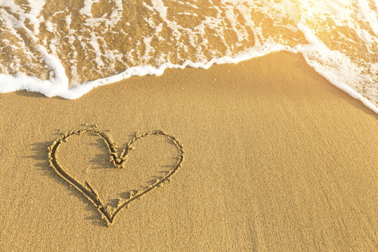 Heart drawn in sea beach sand.