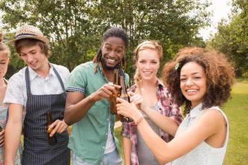 Happy friends in the park having barbecue