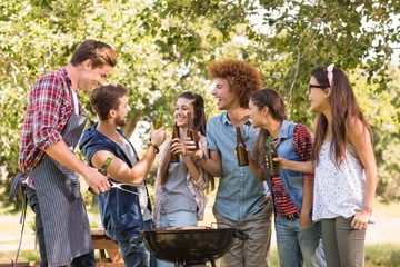 Happy friends in the park having barbecue