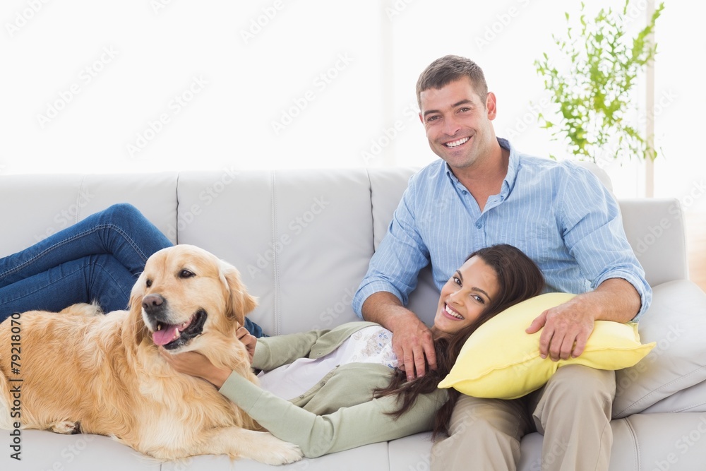 Sticker happy couple with dog relaxing on sofa