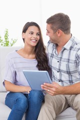 Fototapeta premium Couple with tablet PC sitting on sofa