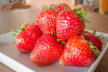 Fresh ripe strawberries on white plate