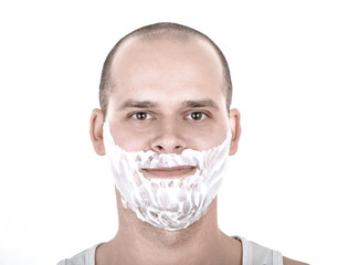 Young man with his face full of shaving cream