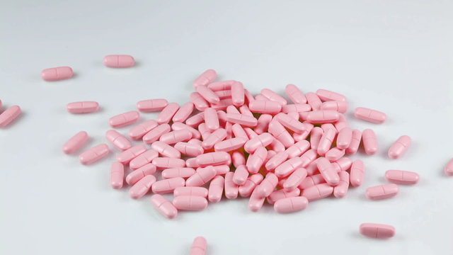 Pink pills falling on the table