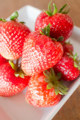 Fresh ripe strawberries on white plate