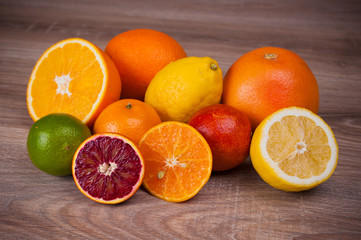 Different citrus fruits on wooden background