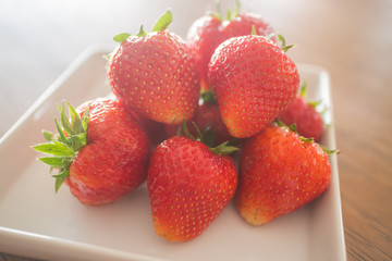 Fresh ripe strawberries on white plate