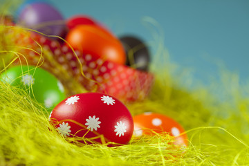 Colored Easter eggs on the grass and blue sky background