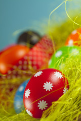 Colored Easter eggs on the grass and blue sky background