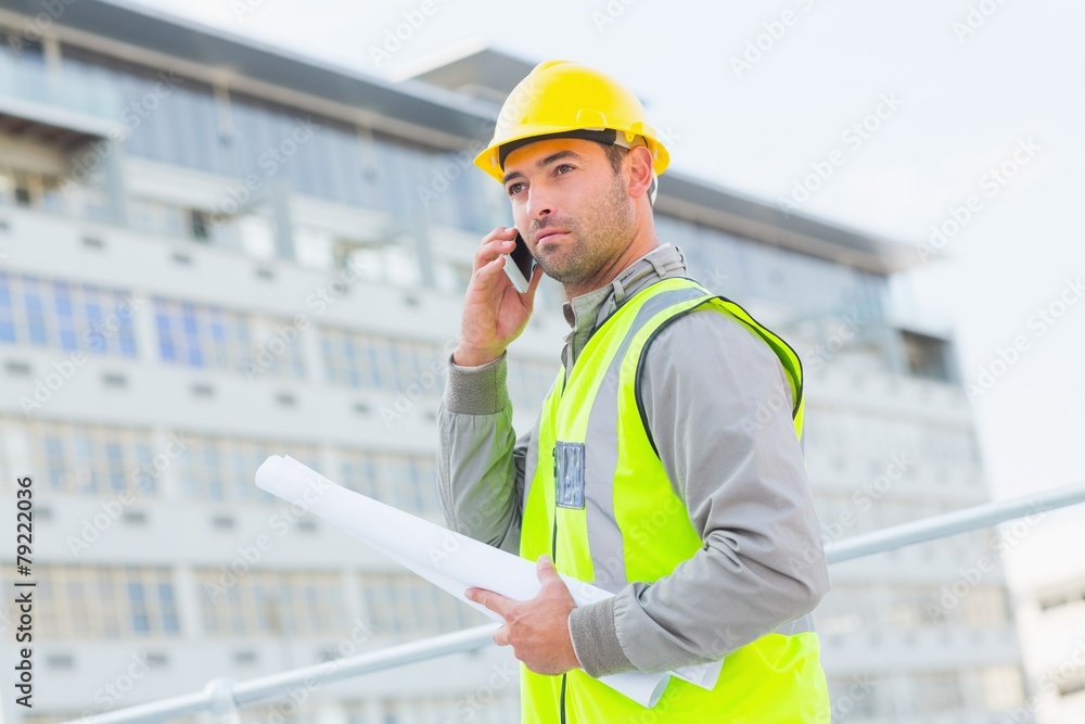 Poster Architect with blueprints using mobile phone against building