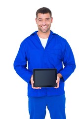 Smiling male mechanic showing digital tablet