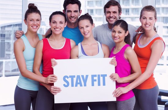 Stay fit against fit smiling people holding blank board
