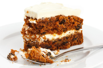 Slice of carrot cake with rich frosting. On plate.
