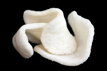 Three prawn crackers arranged on black.