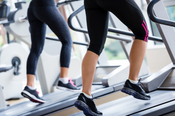 Fototapeta na wymiar friends exercising on a treadmill at the bright modern gym