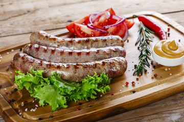 grilled sausages on the grill on the board