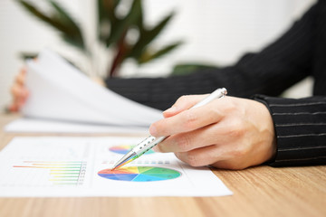 Businesswoman reviewing report and browsing document