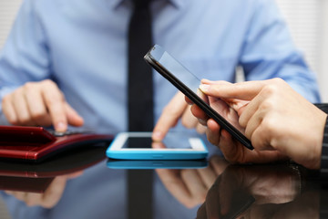 woman is working on mobile phone and businessman in background c