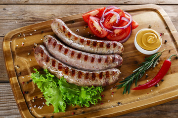grilled sausages on the grill on the board