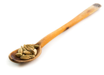 Whole cardamom in wooden spoon