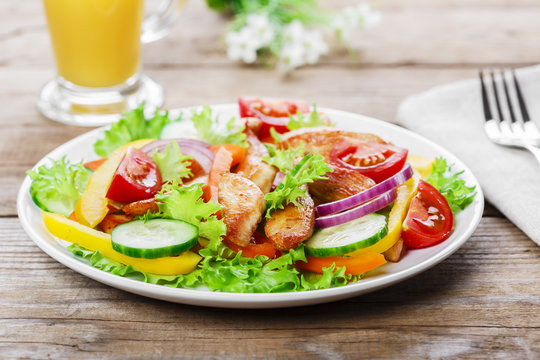 Salad with grilled chicken fillet tomatoes peppers and cucumber