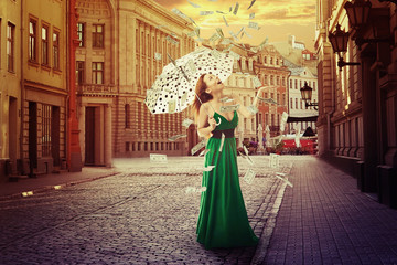 woman with umbrella under a money rain old town street 