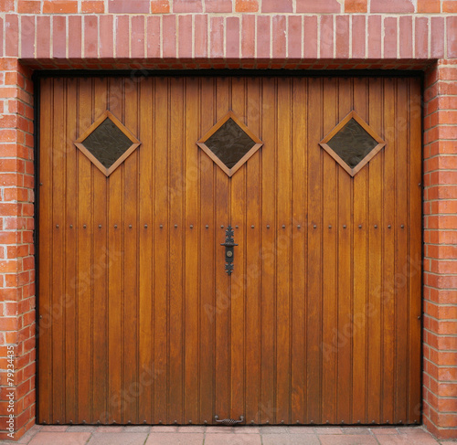 "Gepflegtes Garagentor aus Holz mit Rautenfenstern" Stockfotos und