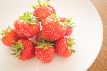 Fresh ripe strawberries on white plate