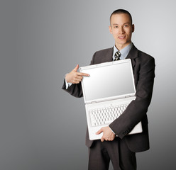 businessman with open laptop shows something