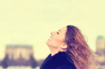 Fototapeta premium Woman smiling looking up to blue sky taking deep breath