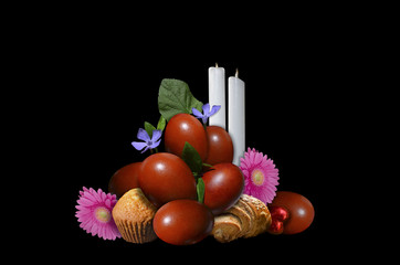 Easter eggs with pastries and candles on a black background