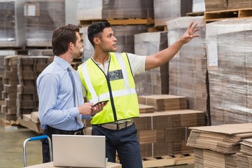 Warehouse worker showing something to his manager