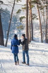 Fototapeta na wymiar Couple walking in winter forest