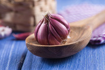 Fresh organic whole garlic on wooden spoon