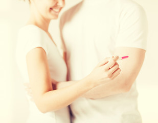 Obraz na płótnie Canvas woman and man hands with pregnancy test