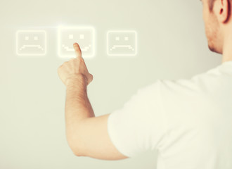 hand touching virtual screen with smile button