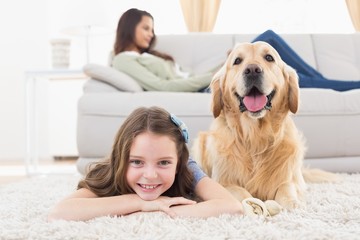 Girl with dog lying on rug at home © WavebreakmediaMicro