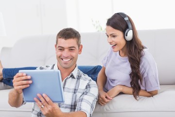 Man showing digital tablet to surprised woman