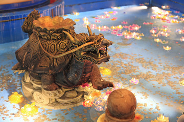 Turtle dragon statue on pond with floating candle light