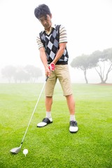 Fototapeta premium Concentrating golfer lining up his shot
