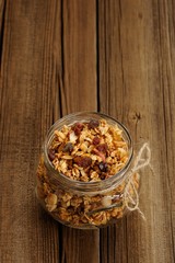 Granola in jar with packing-twine on wooden background with spac