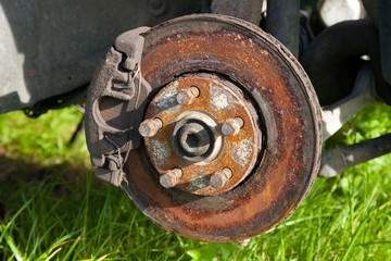 Front disk brake on car in process of damaged tyre replacement