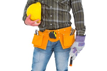 Manual worker wearing tool belt while holding gloves and helmet