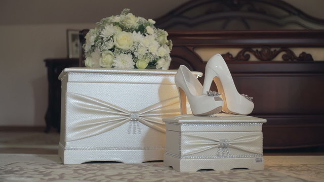 DOLLY MOTION: wedding shoes and bouquet on a white chair